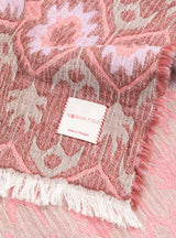 Manta Maison Figo com design Ikat em tons rosa, lilás e verde.