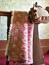 Manta Maison Figo com design Ikat em tons rosa, lilás e verde.