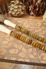 Pincel pequeno com pedras em tons mel e verde