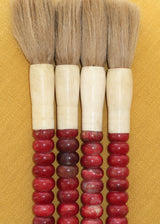 Pincel decorativo em tons vermelho cereja