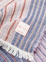 Manta Maison Figo com riscas em tons rosa, azul e bordeaux.